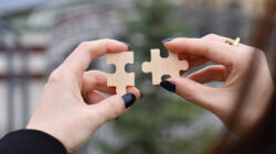 A person joining two pieces of a puzzle.
